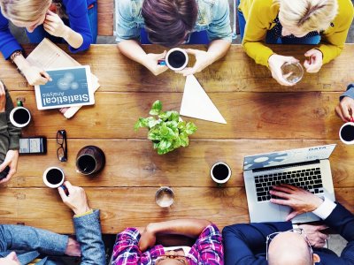 Office coffee: Employees gather for a meeting over a cup of coffee.