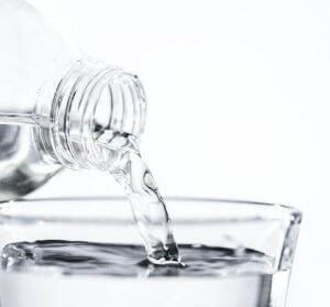 patient hydration - water pouring out of bottle into glass