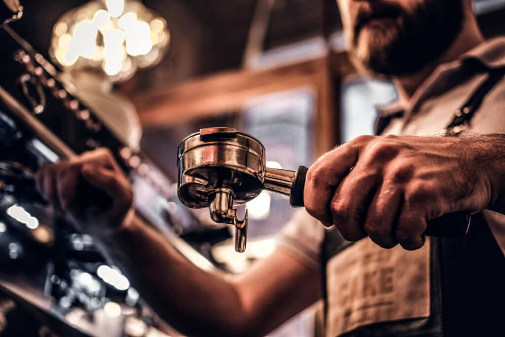 barista cleans portafilter